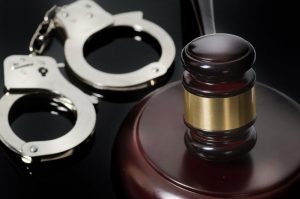 Gavel and pair of handcuffs on a table 
